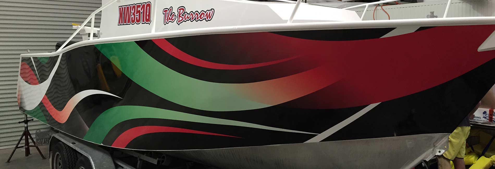 Style design in green red and black fade on side of boat wrap